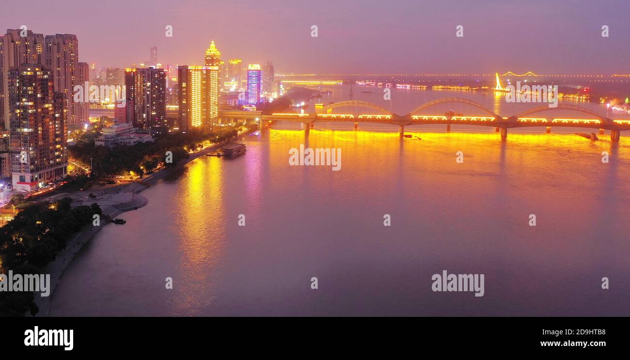 Una vista aérea de toda la zona urbana que se enciende a medida que llega la noche y las lámparas dentro de las casas, las luces de los automóviles y las farolas se encienden, Harbin c Foto de stock