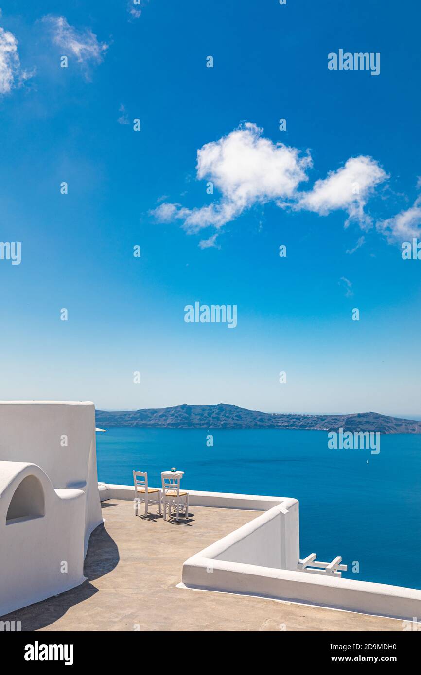 Arquitectura blanca en la isla de Santorini, Grecia. Restaurante al aire libre bajo un paisaje fantástico, sillas para la pareja. Vista romántica, vacaciones de verano Foto de stock