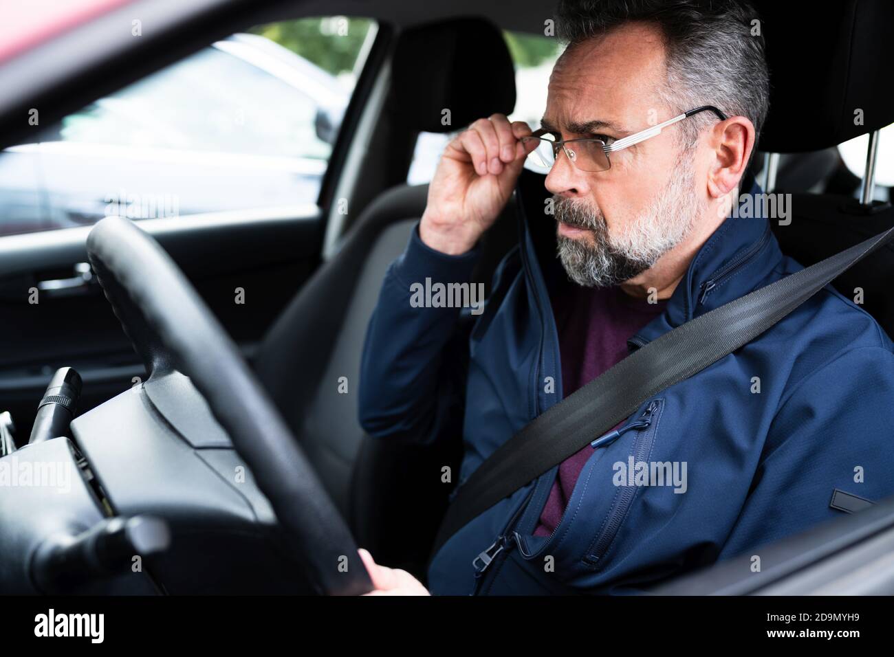 Conductor de coche anciano en el asiento delantero Foto de stock