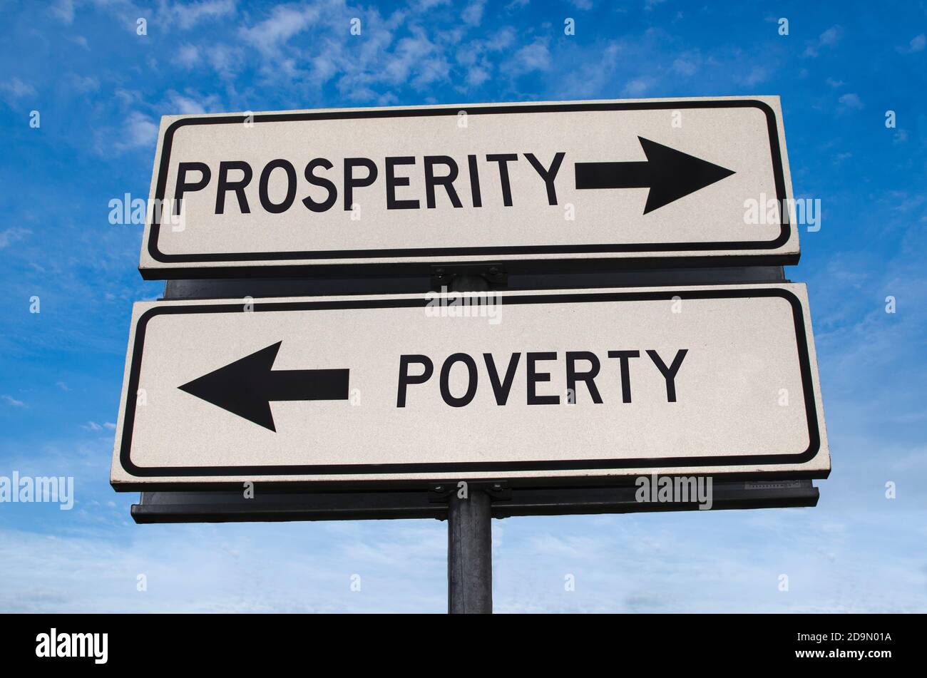 Pobreza versus prosperidad flecha blanca señal de camino en el cielo azul de fondo. Dos señales de calle blancas con flecha en el poste de metal con palabra. Carretera direccional. Foto de stock