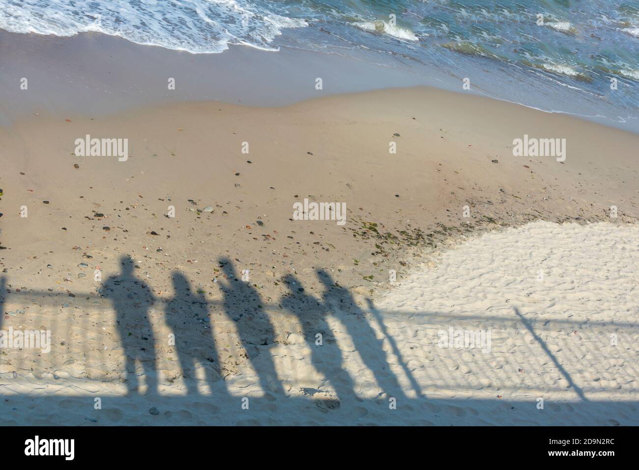 Sombras de grupo de personas en la costa. Concepto de recuerdo, pandemia, salida a otra realidad. Foto de stock