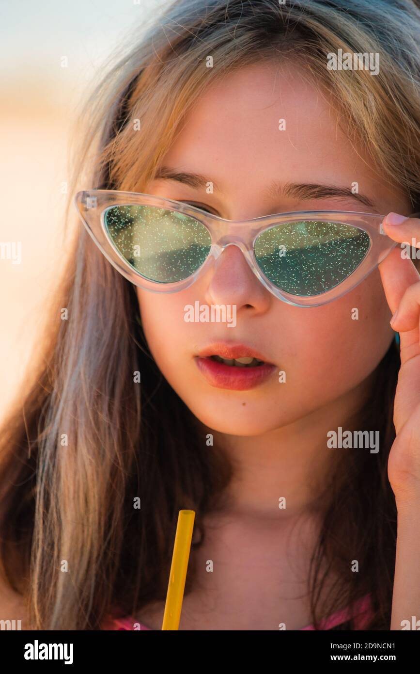Niña de 10 años en el mar. Retrato de un adolescente. Chica en gafas de sol  bebe de una pajita una bebida en el mar en la playa Fotografía de stock -  Alamy