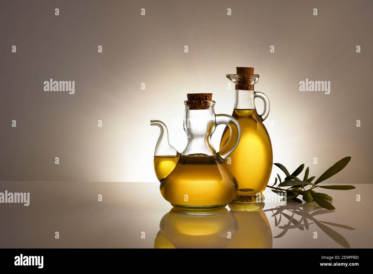Envases de vidrio llenos de aceite de oliva retroiluminado sobre mesa de  vidrio y fondo aislado gradiente gris. Composición a la derecha con espacio  para texto Fotografía de stock - Alamy