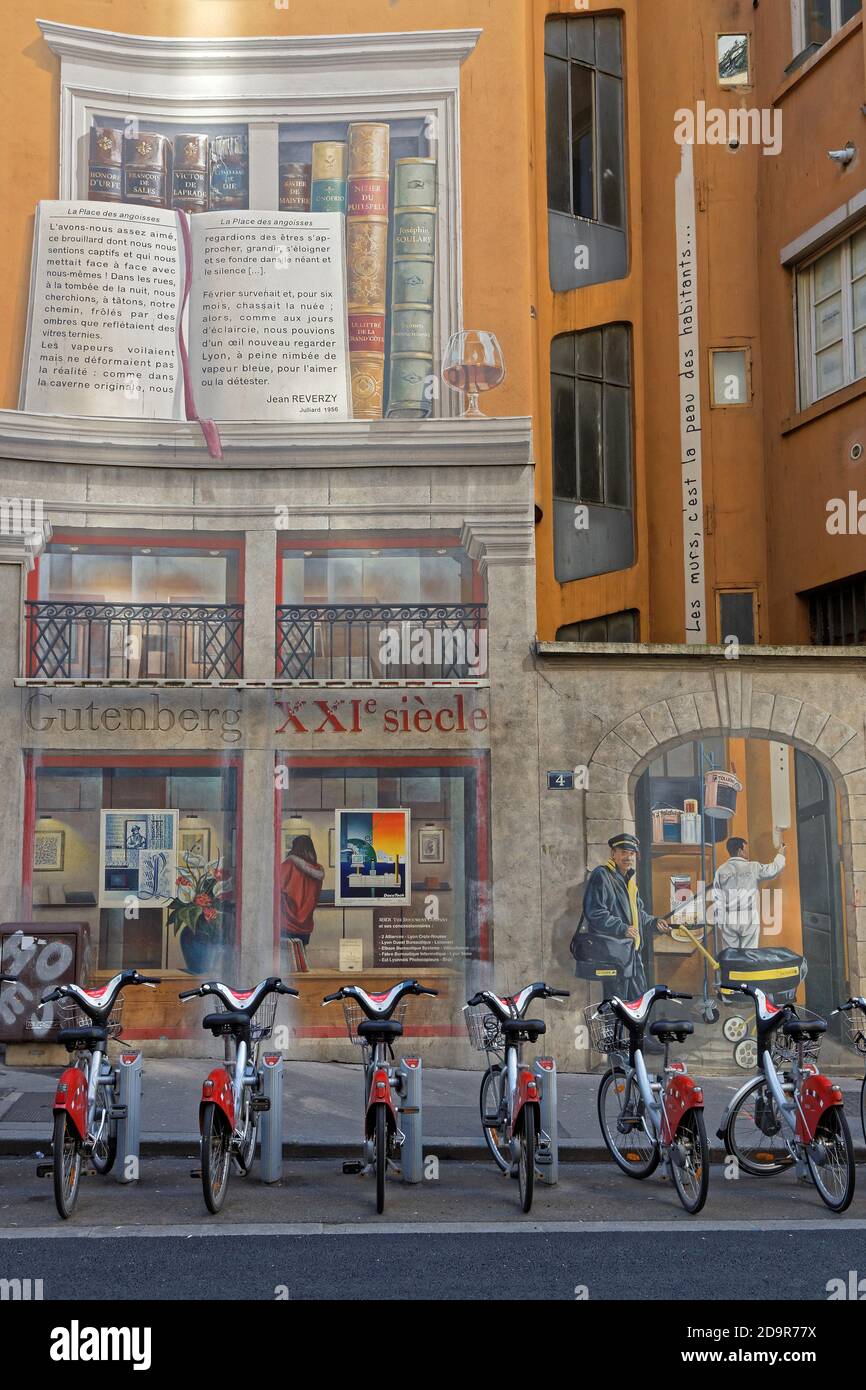 LYON, FRANCIA, 13 de enero de 2018 : Bibliothèque de la Cité pintura mural. Muestra una inmensa estantería que contiene obras de varios cientos de escritores de Foto de stock