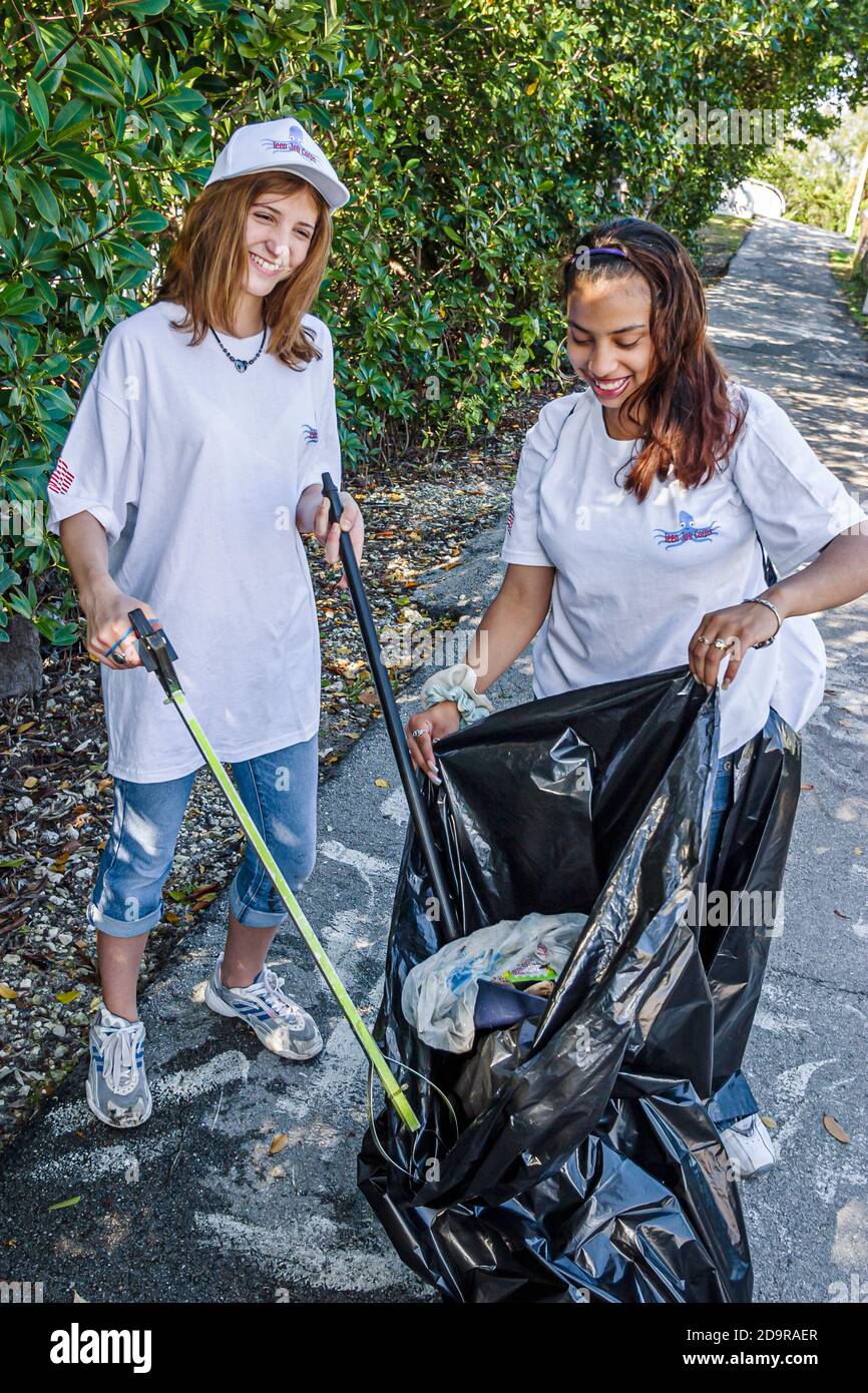 Miami Beach Florida, adolescentes adolescentes voluntarios del Cuerpo de Trabajo, niñas hispanas africanas negras llenando bolsa de basura, limpieza Tatum Water Foto de stock