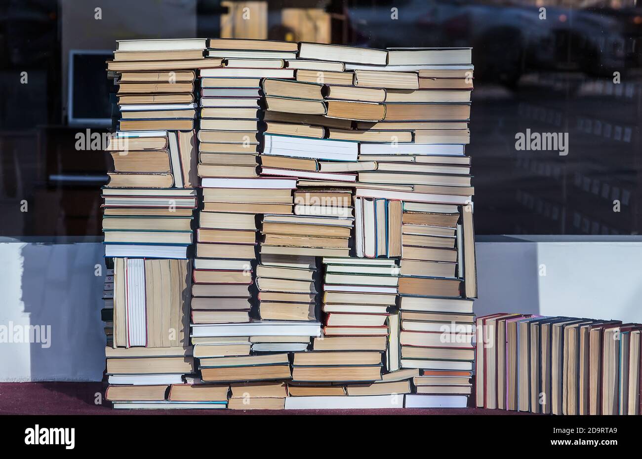 Una pila de libros antiguos y nuevos de diferentes tamaños y formas apilados de una manera caótica. Primer plano. Foto de stock