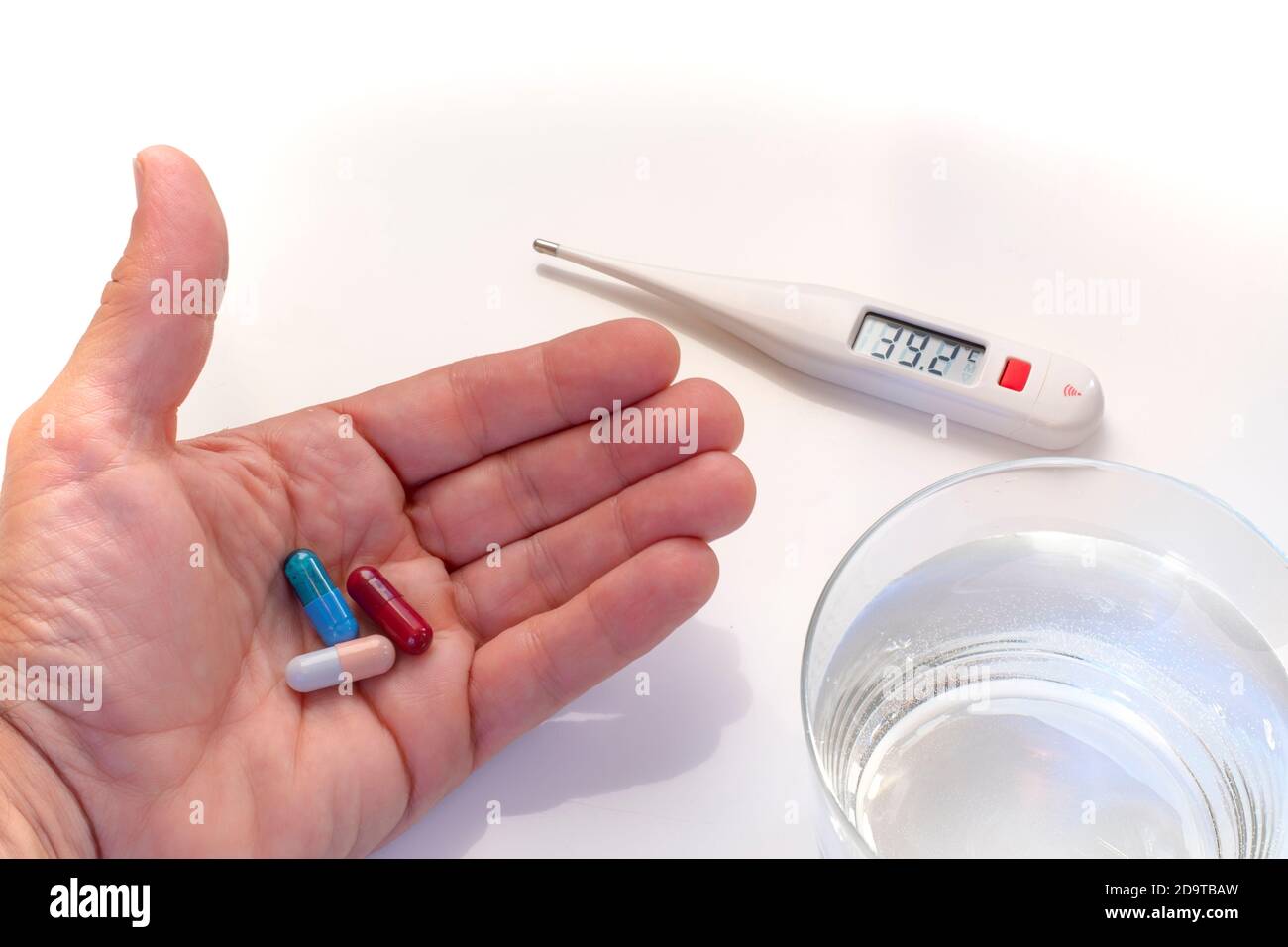 termómetro digital que muestra los valores de fiebre, pastillas de árbol de  mano y vaso de agua Fotografía de stock - Alamy