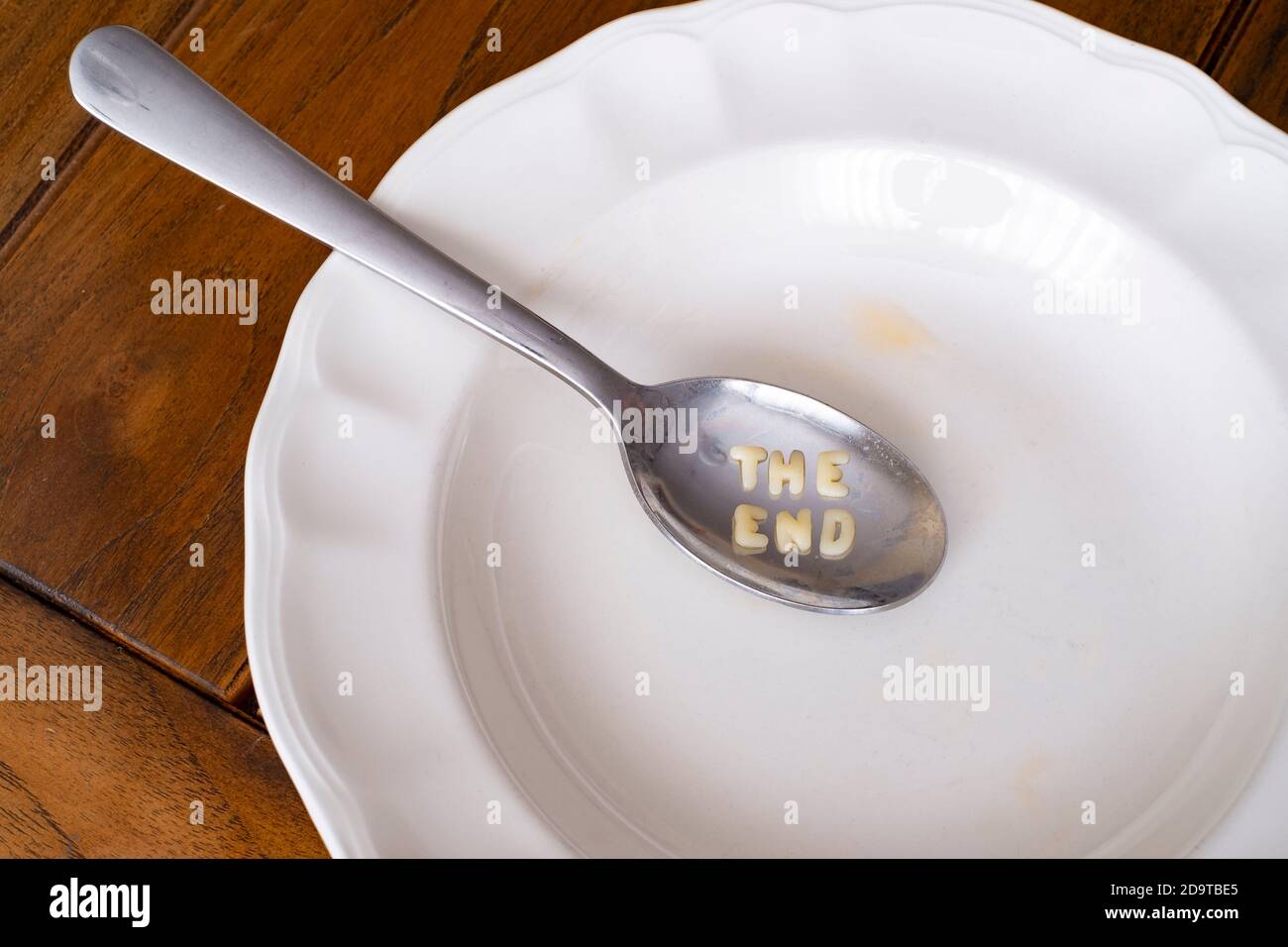 plato de sopa de alfabeto vacío con el mensaje del extremo dentro de una  cuchara en un plato blanco sobre una mesa de madera, vista superior  Fotografía de stock - Alamy