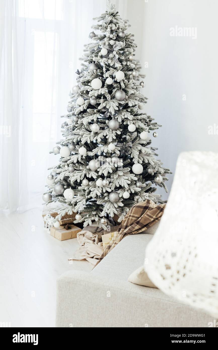 Árbol de Navidad blanco y nevado con decoración de regalos interior de la  tarjeta postal de año nuevo de la casa Fotografía de stock - Alamy