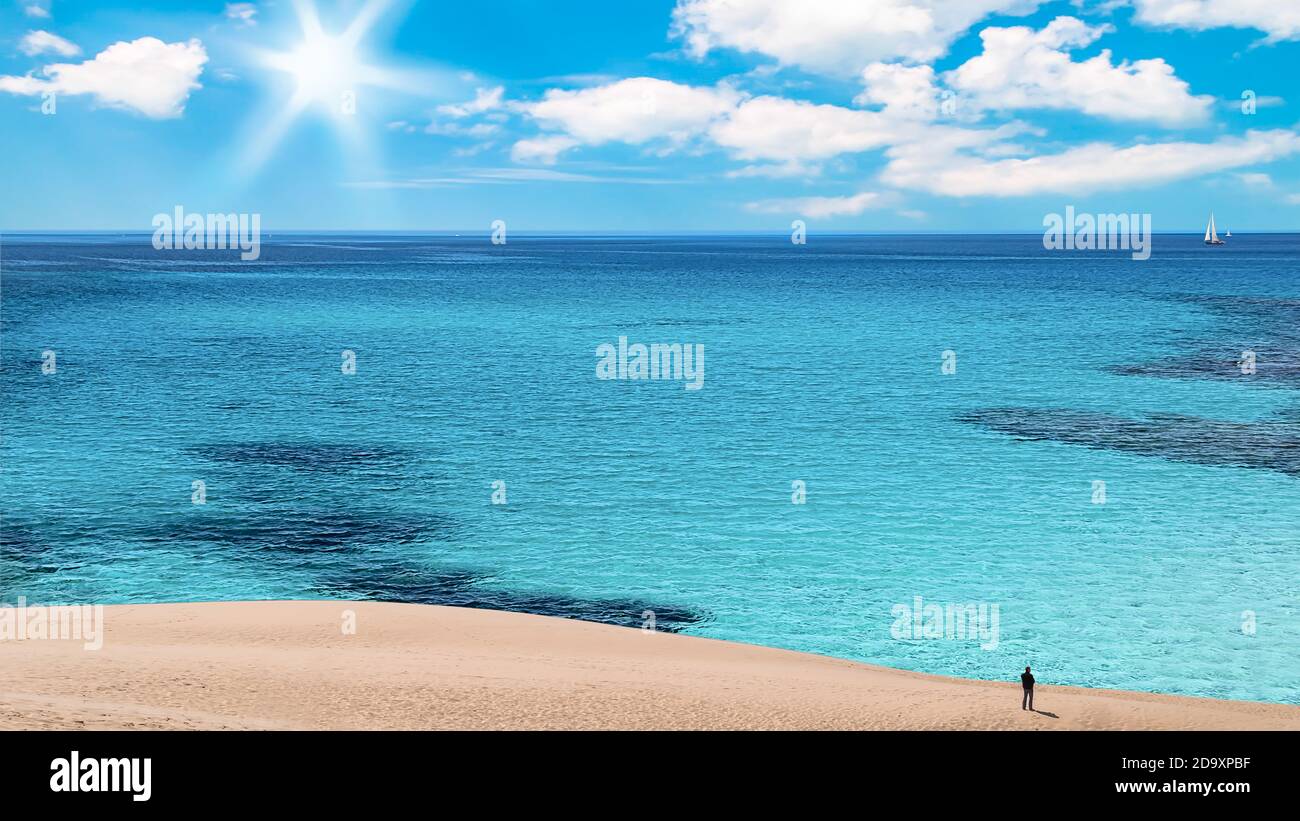 Una persona mirando el océano en el paisaje costal con Blue Sky y.. Foto de stock