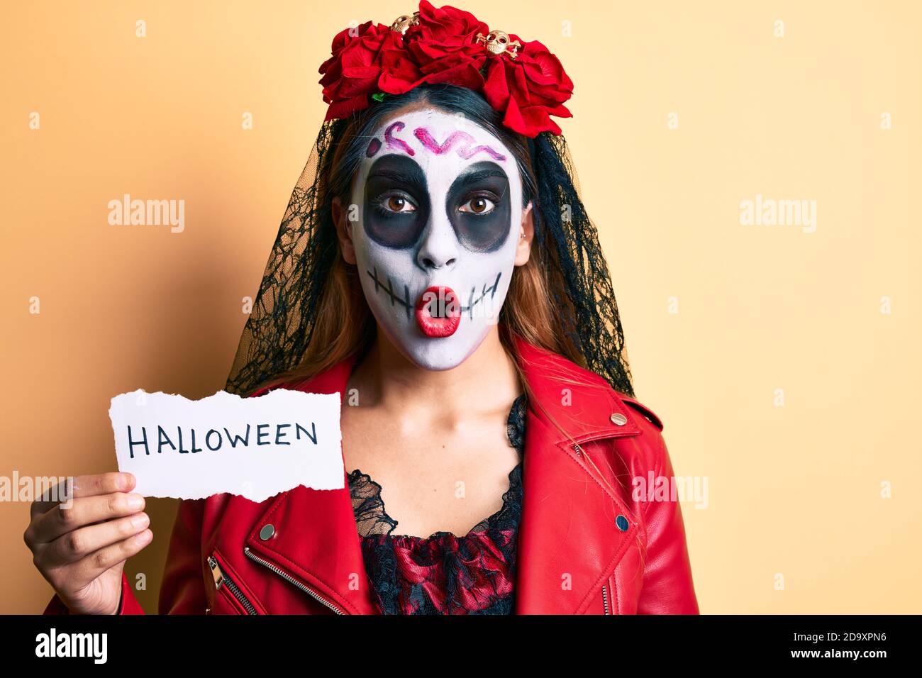 Mujer que llevaba el día de la muerte disfraz sosteniendo papel de halloween  asustado y sorprendido con boca abierta para sorpresa, cara de incredulidad  Fotografía de stock - Alamy