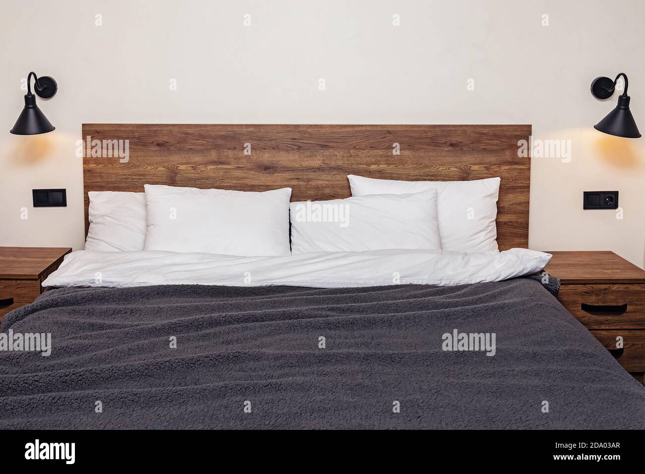 Habitación interior moderna y minimalista. Cama con almohadas blancas en la  cabecera de madera Fotografía de stock - Alamy