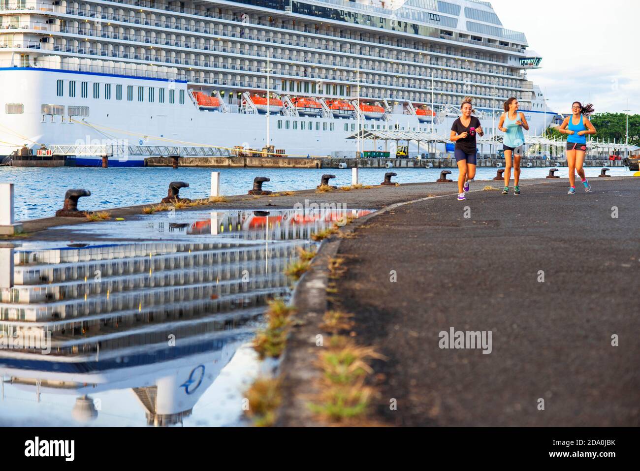 Mujer corriendo delante de MS Marina atracó en el puerto de Papeete. Tahití, Polinesia Francesa, Puerto de Papeete, Tahití Nui, Islas de la Sociedad, Polino Francés Foto de stock