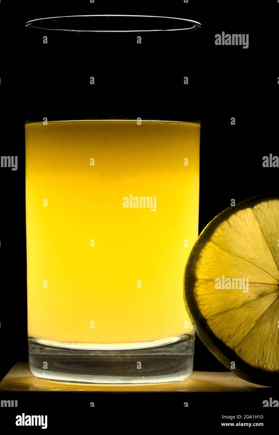 Jugo de cítricos de bergamota en un vaso con una rebanada de fruta en transparencia. Foto de stock