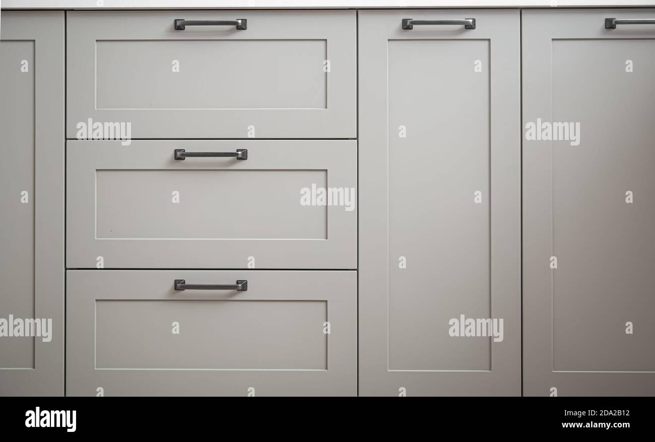 Armarios blancos de cocina con tiradores de metal o perillas en las puertas  de cerca Fotografía de stock - Alamy