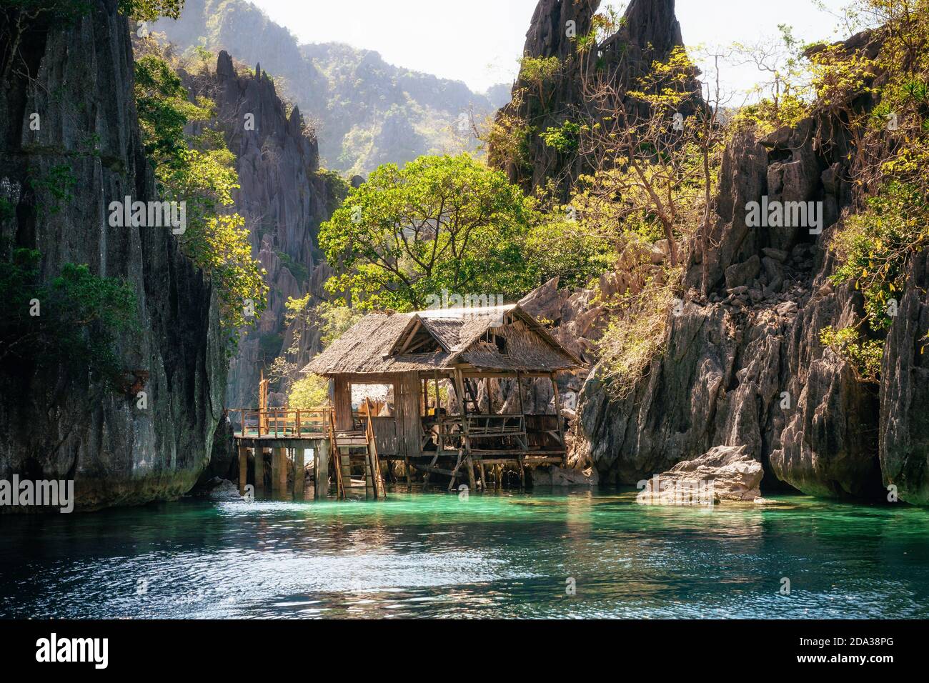 Vista de la cabaña de madera en el mar tranquilo contra la formación de rocas, Filipinas Foto de stock