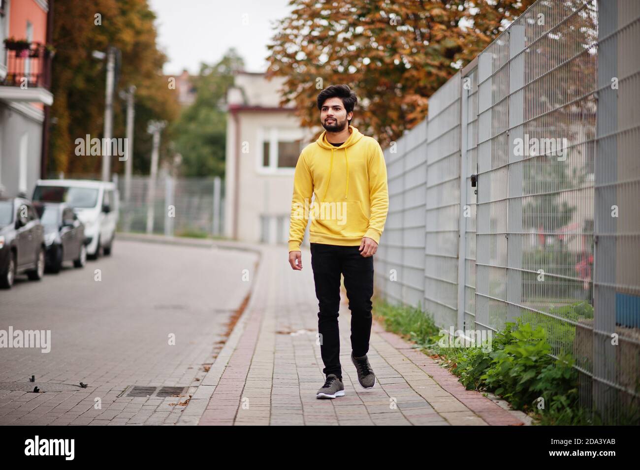 Joven hipster urbano hombre indio en una moderna sudadera amarilla. El  chico fresco del sur de asia usa hoodie caminando en la calle de otoño  Fotografía de stock - Alamy