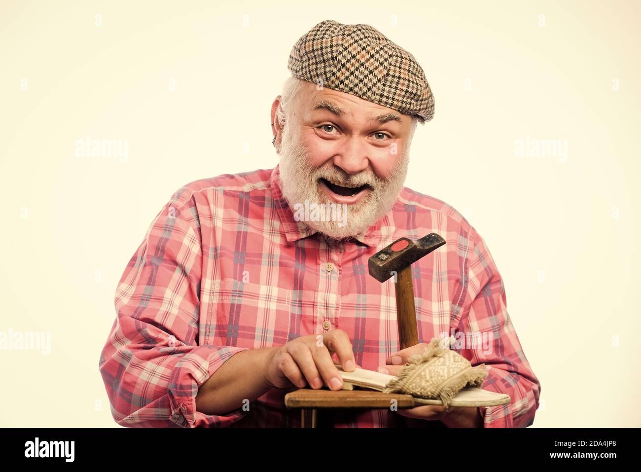 Concepto hecho a mano. Diseño de zapatillas. Trabajador artesano. Taller de  reparación de zapatos. Maestro mayor con zapata reparadora de martillo. Zapatillas  personalizadas. Hombre barbudo handyman trabajando con herramientas fondo  blanco Fotografía