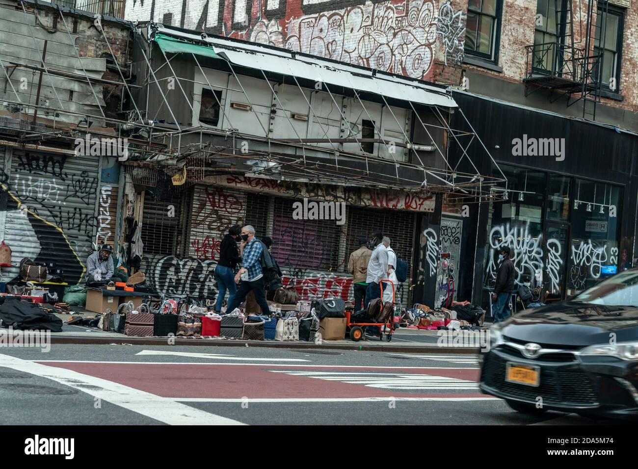 Nueva York, NY - 9 de noviembre de 2020: Vendedores ambulantes venden artículos falsificados como bolsas, gafas de sol, cinturones y relojes en Canal Street y Broadway corners Foto de stock