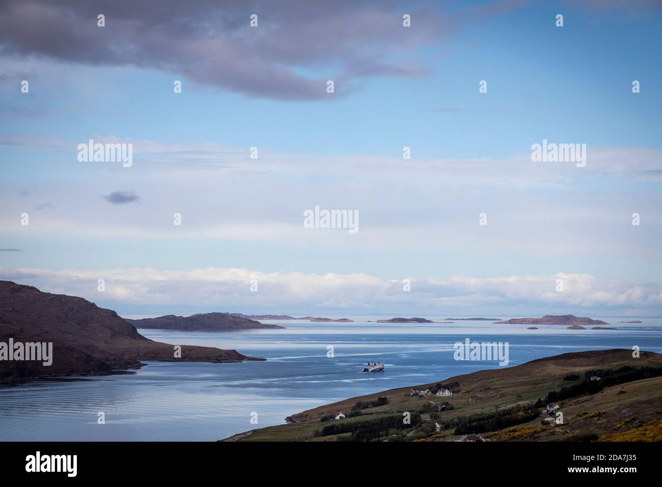 Vista del ferry Caledonian MacBrayne (CalMac) mientras se dirige hacia las Islas de Verano, visto desde las colinas por encima de Ullapool, Escocia. Foto de stock