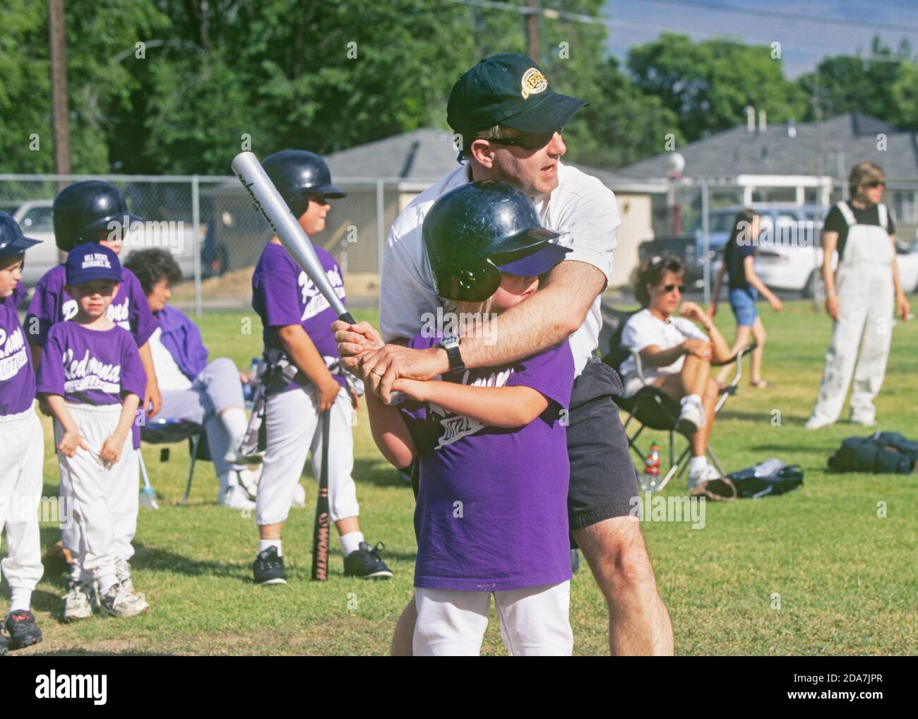 Un partido de béisbol de Llittle League en marcha en un parque urbano en Redmond, Oregón, durante el verano. Foto de stock