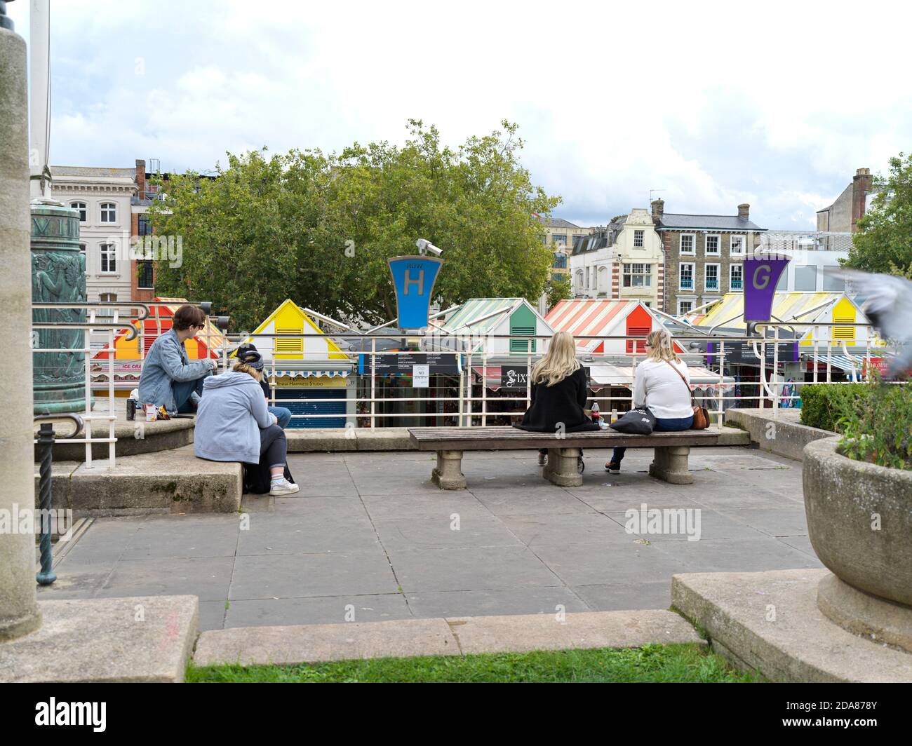 Estudiantes sentados aparte mirando el mercado Norwich durante las regulaciones de Covid en 2020 Foto de stock