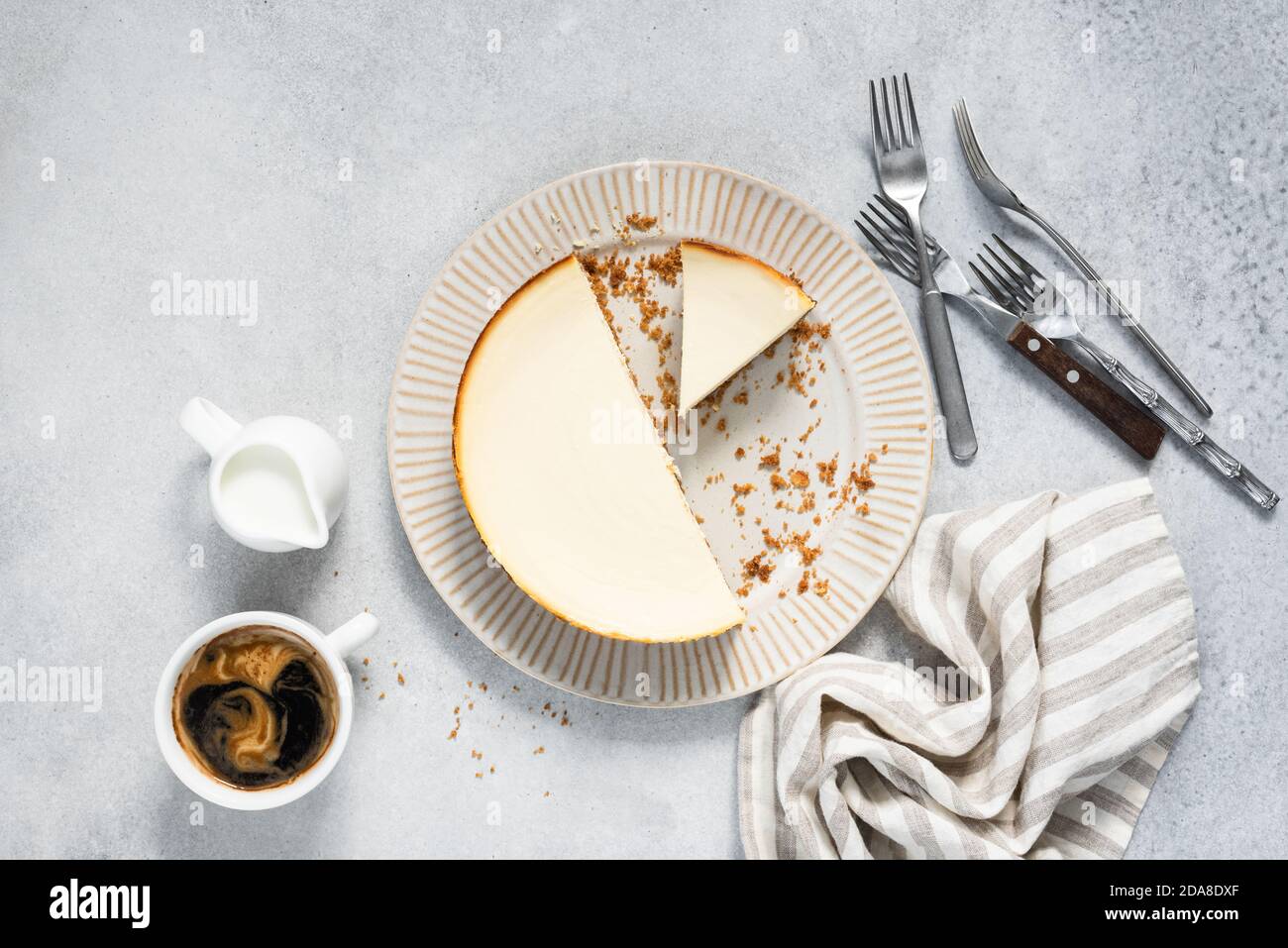 Tarta de queso cortada en el plato y café sobre un fondo de hormigón gris, vista superior. Sabrosa tarta de queso Foto de stock