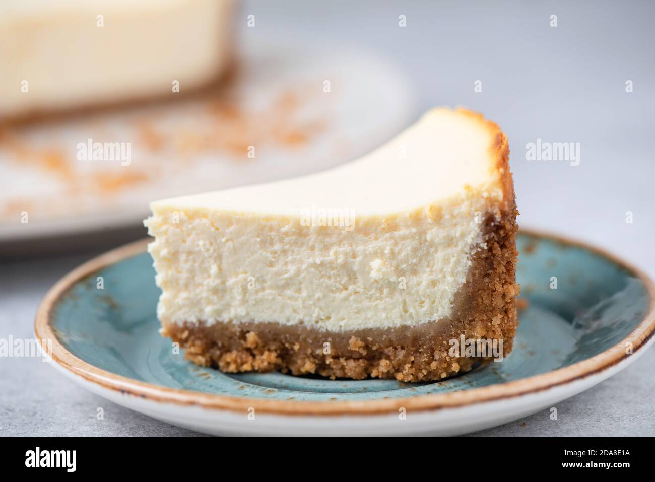 Corte de Cheesecake clásico de Nueva York en un plato azul, Vista de primer plano, enfoque selectivo Foto de stock