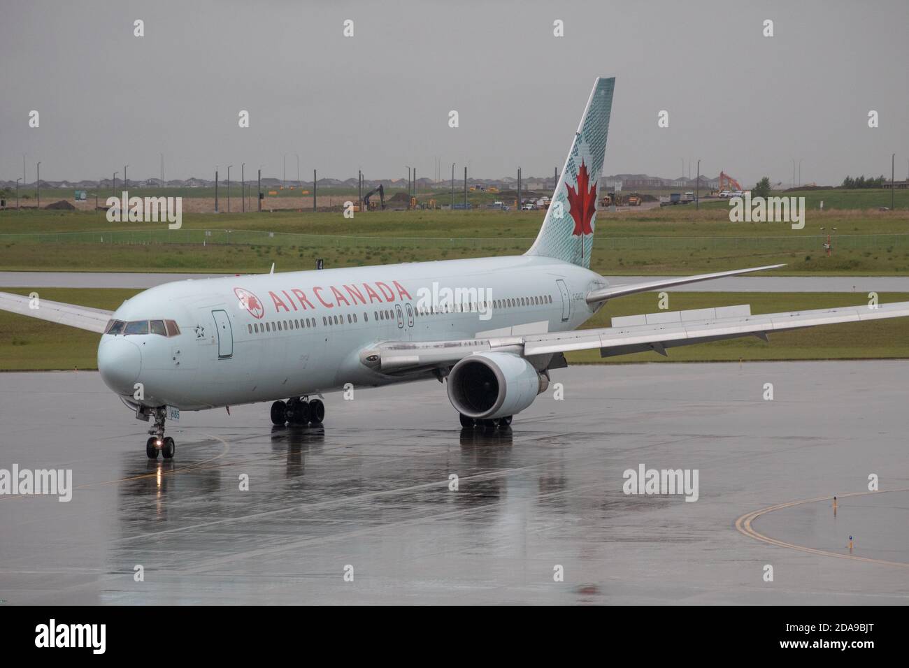 Air Canada 767 jet llegando bajo la lluvia a Calgary Aeropuerto Internacional (YYC) Foto de stock