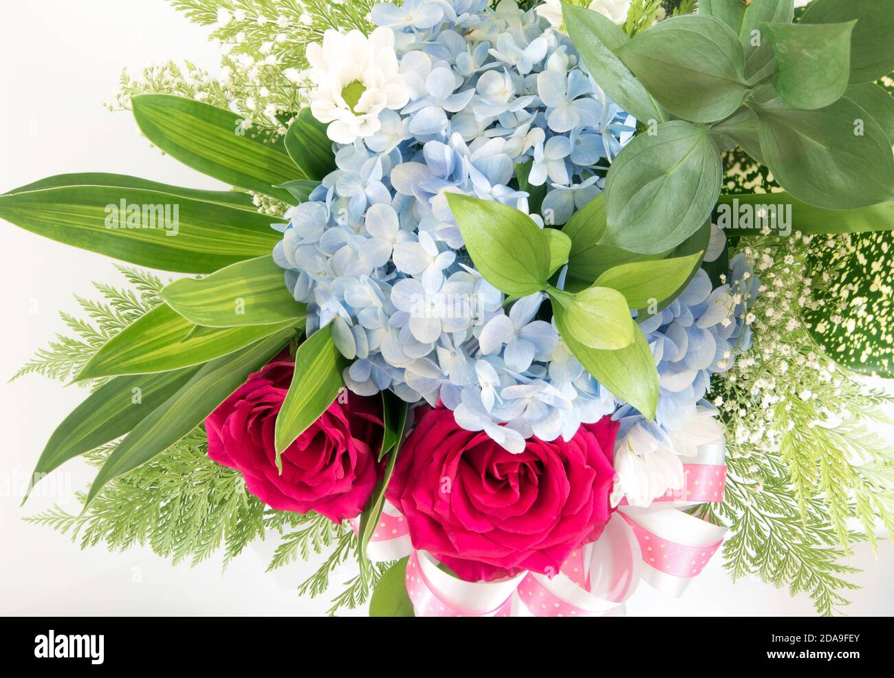 Rosas rojas grandes y pequeñas flores azules frágiles y inserto hojas en el  hermoso ramo de flores Fotografía de stock - Alamy