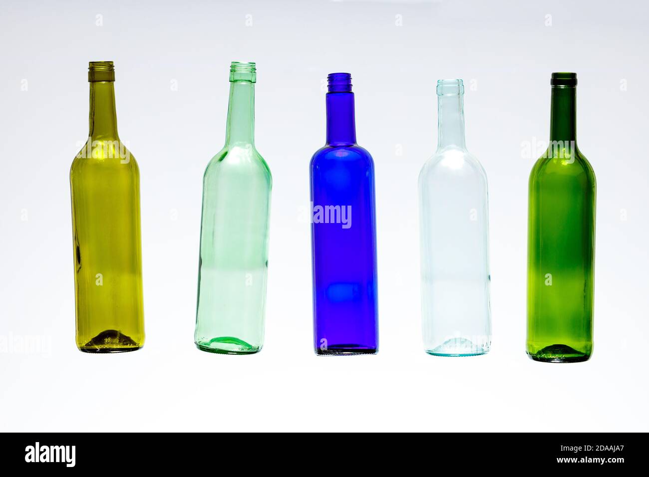 cinco botellas de vino vacías de colores Foto de stock