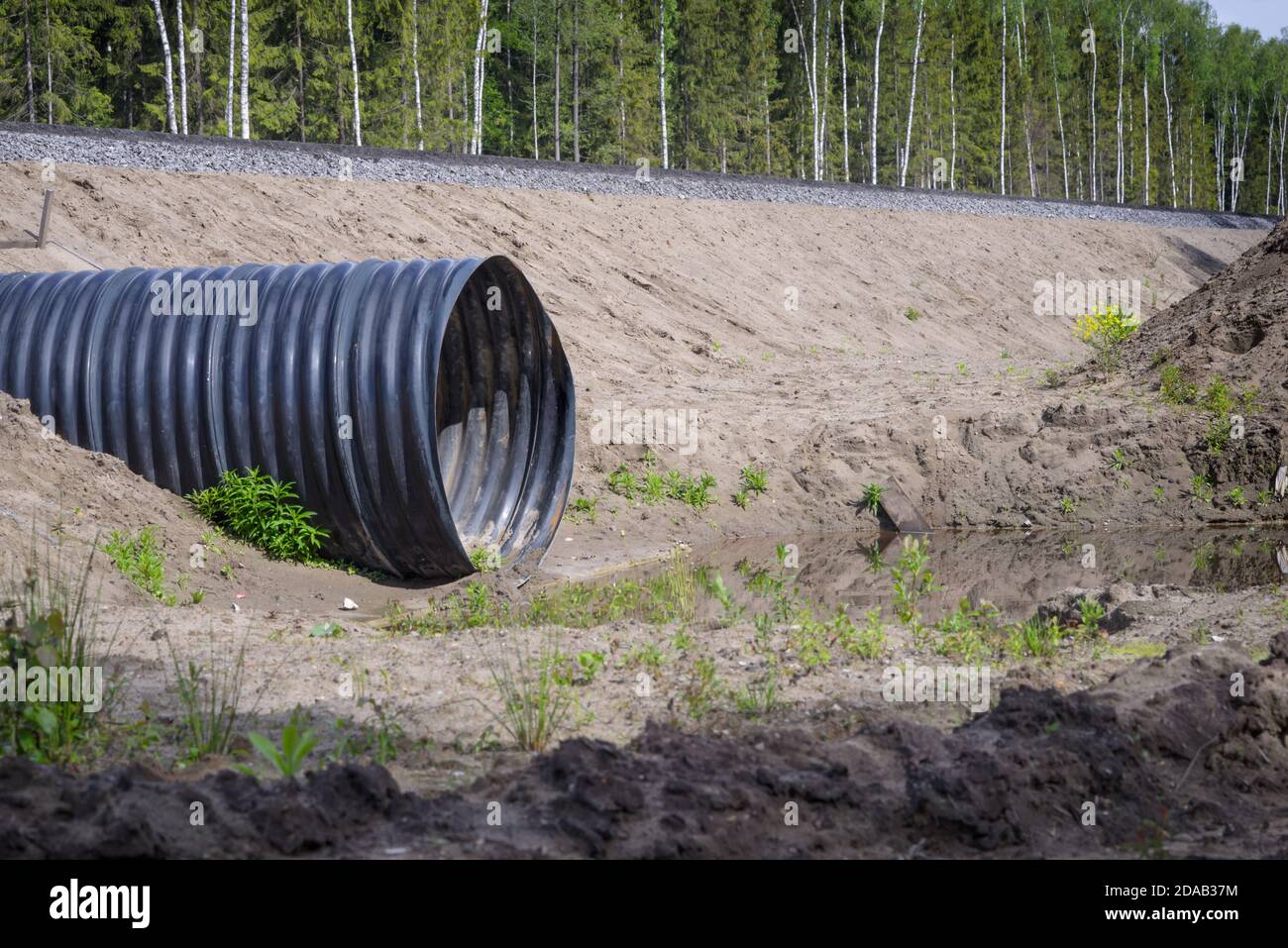 Nuevo tubo de drenaje de metal corrugado instalado en zanja debajo el camino  Fotografía de stock - Alamy