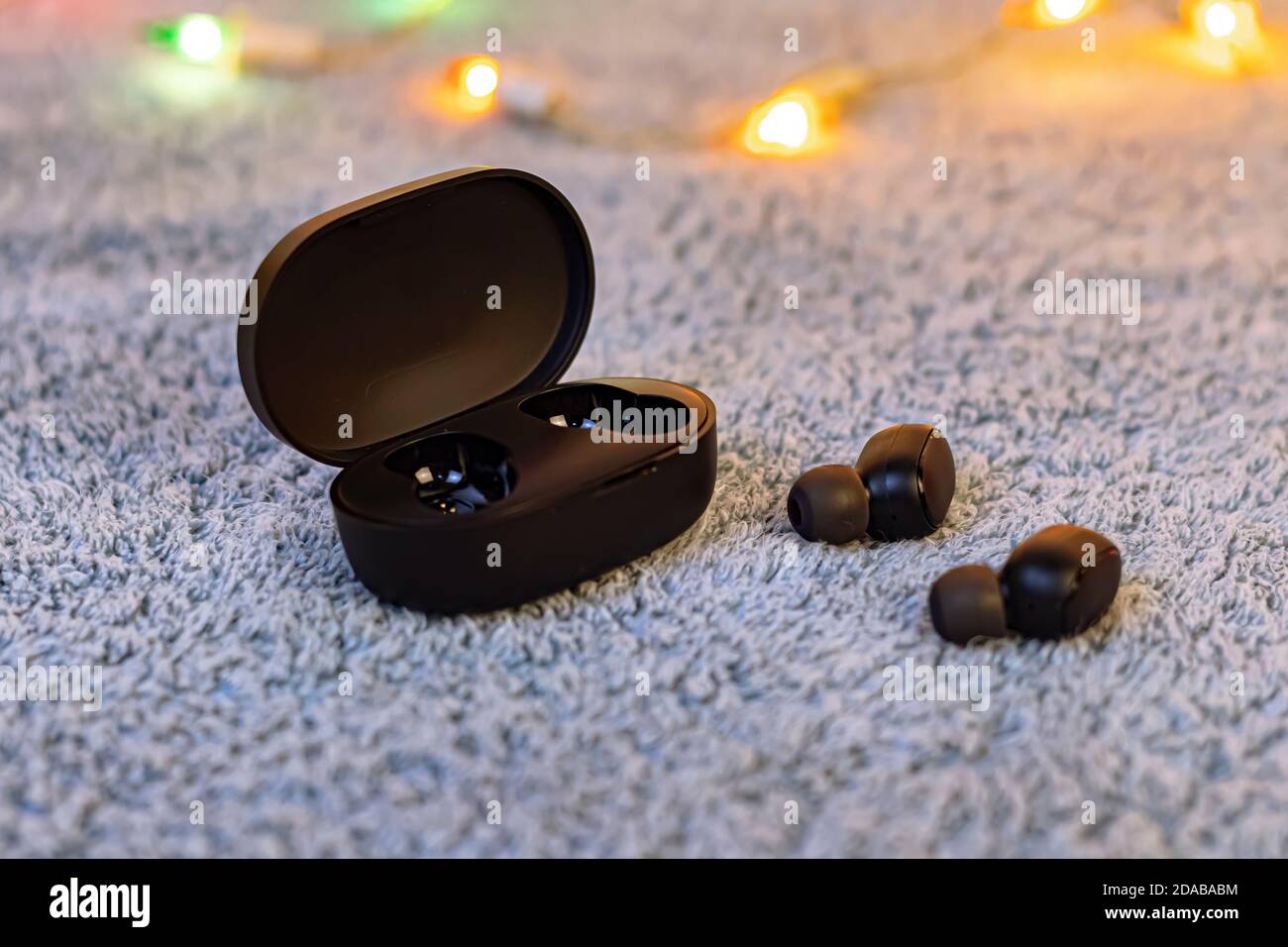Auriculares inalámbricos negros aislados sobre felpa gris Fotografía de  stock - Alamy
