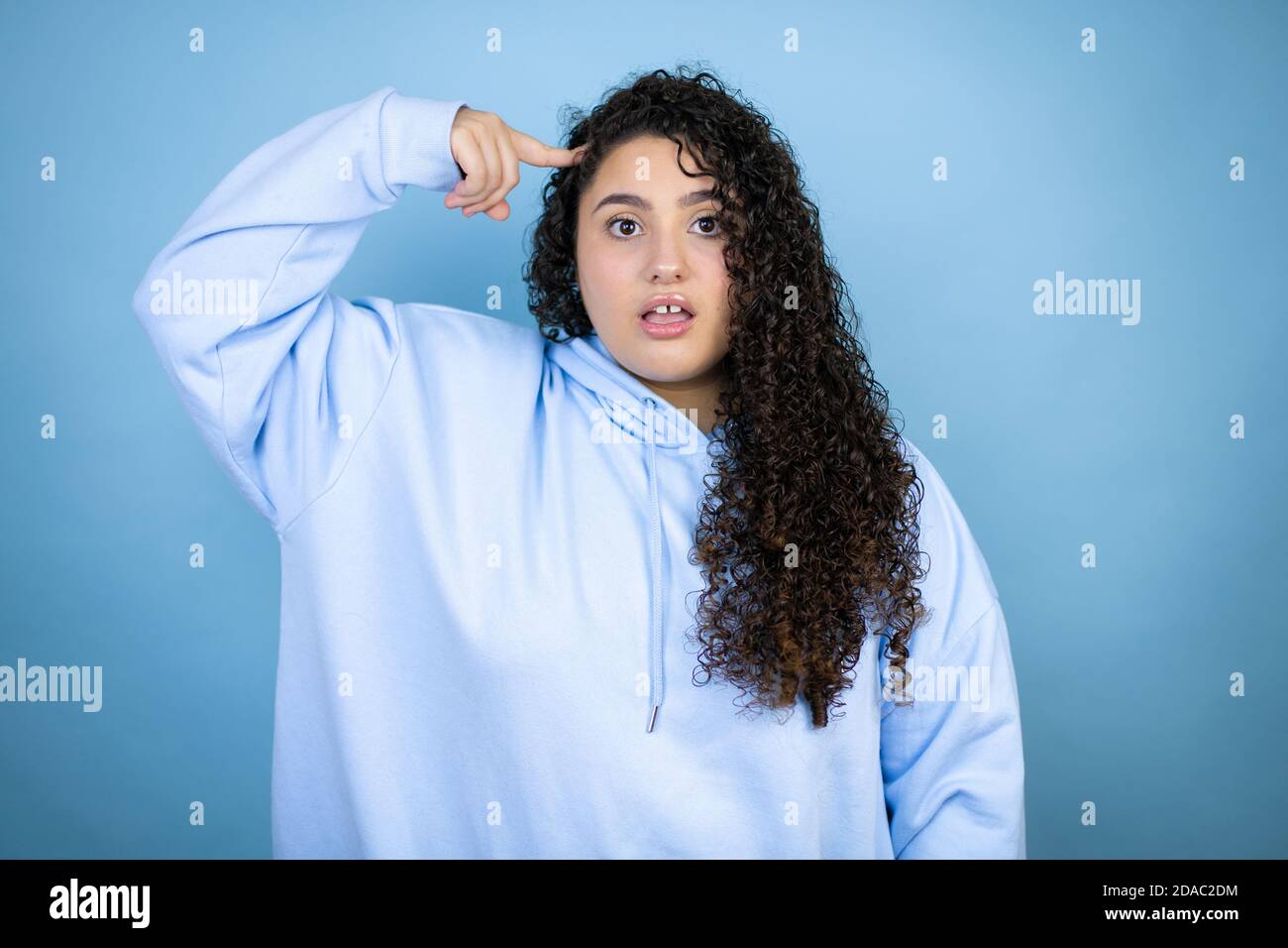 Joven hermosa mujer con sudadera casual sobre fondo azul aislado sonriendo  y pensando con sus dedos en su cabeza que ella tiene una idea Fotografía de  stock - Alamy