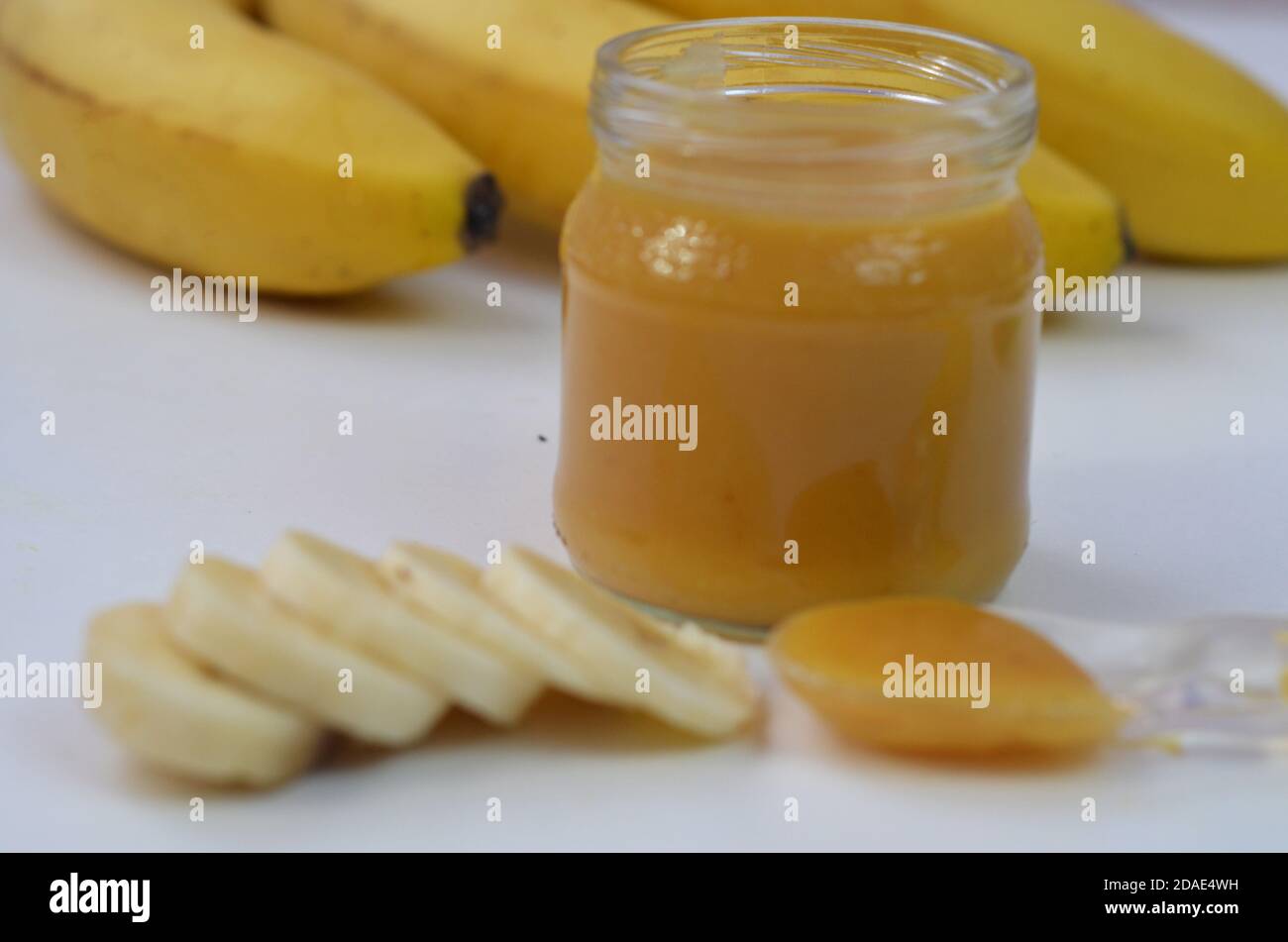 Comida para bebés, puré de patatas y plátanos en un fondo blanco está aislado. Foto de stock