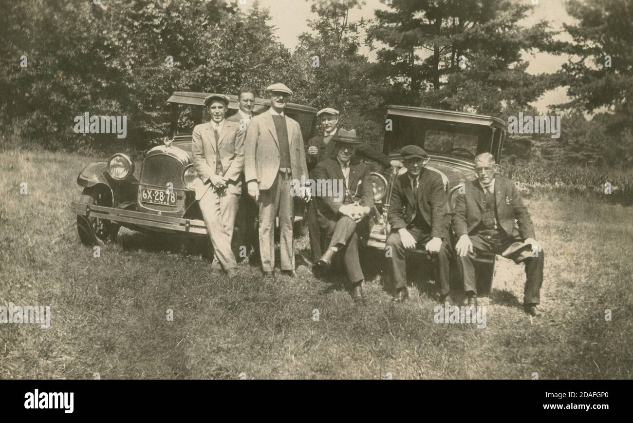 Fotografía antigua, grupo de hombres en un campo con dos coches con una placa de matrícula de Nueva York 1926. FUENTE: FOTOGRAFÍA ORIGINAL Foto de stock
