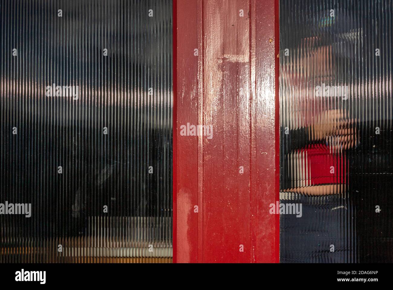 Un hombre lleva a cabo reparaciones de bricolaje detrás de vidrio esmerilado en el interior de un bar/restaurante durante el cierre 2. Londres Foto de stock