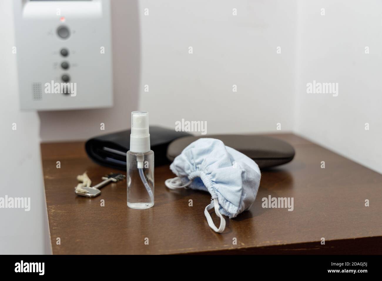 Preparación para una pandemia antes de salir de casa: Mascarilla facial y desinfectante en una pequeña y práctica botella Foto de stock