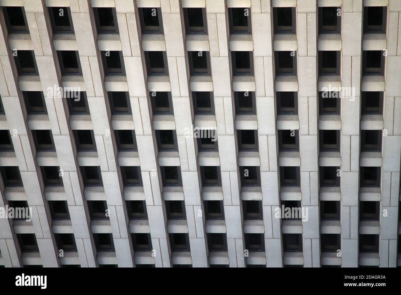 El patrón de ventanas regulares en un edificio de concreto Foto de stock