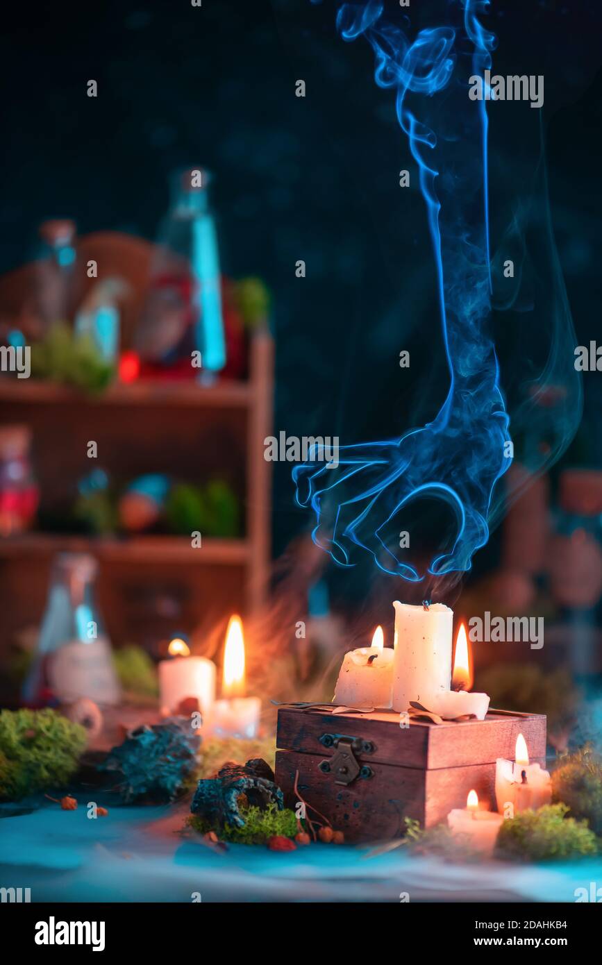 Mano de humo mística que distingue una vela, fantasma creepy en todavía  mágico Fotografía de stock - Alamy