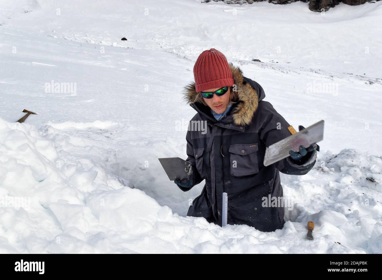 Hombre con gafas de sol trabajando en la nieve fotografías e