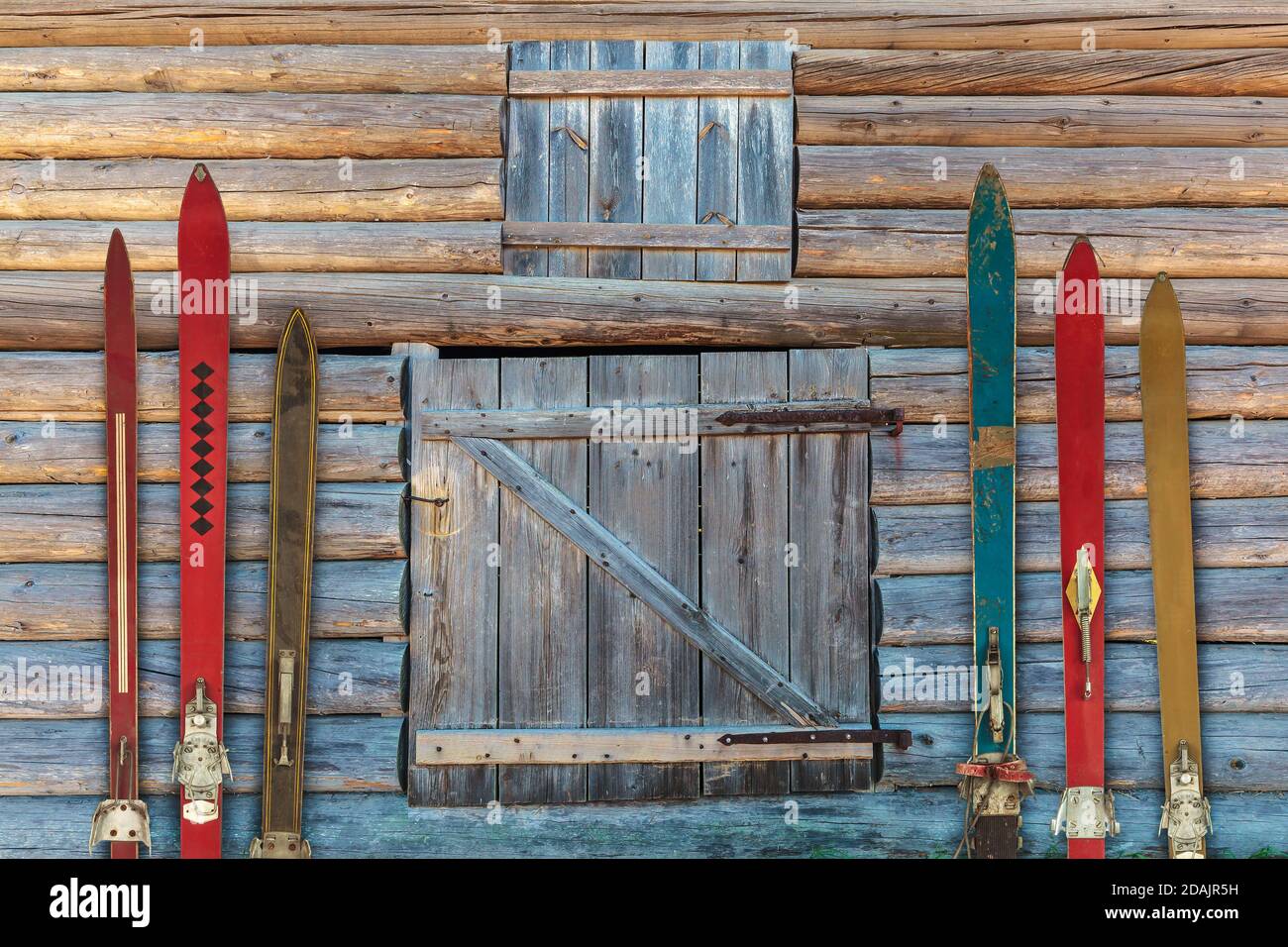 Colección de esquí de época de madera envejecida delante de un antiguo granero Foto de stock