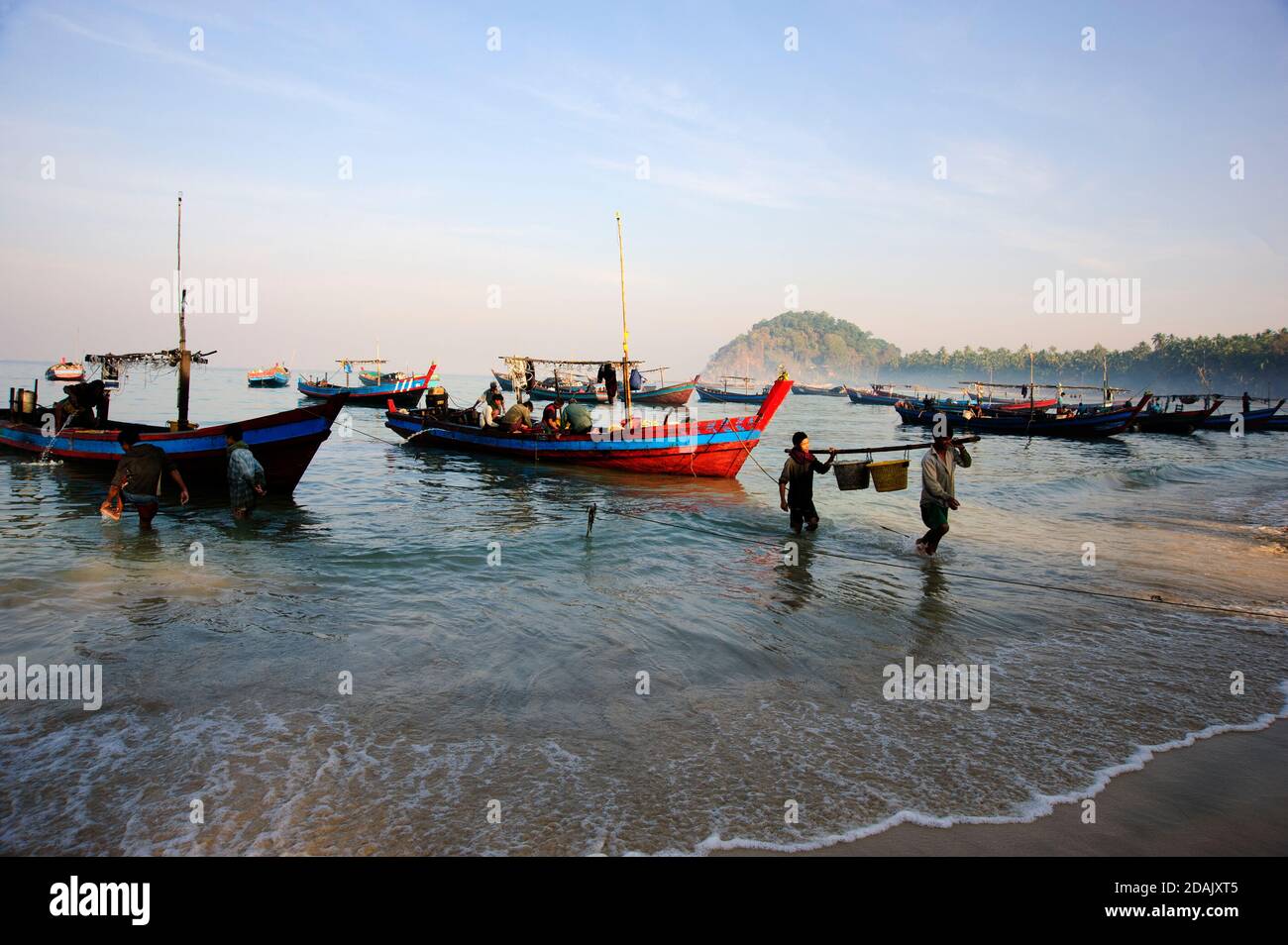 Los pescadores birmanos traen sus nigfhts captura tierra como el sol Se eleva en la playa Ngapali Myanmar Foto de stock