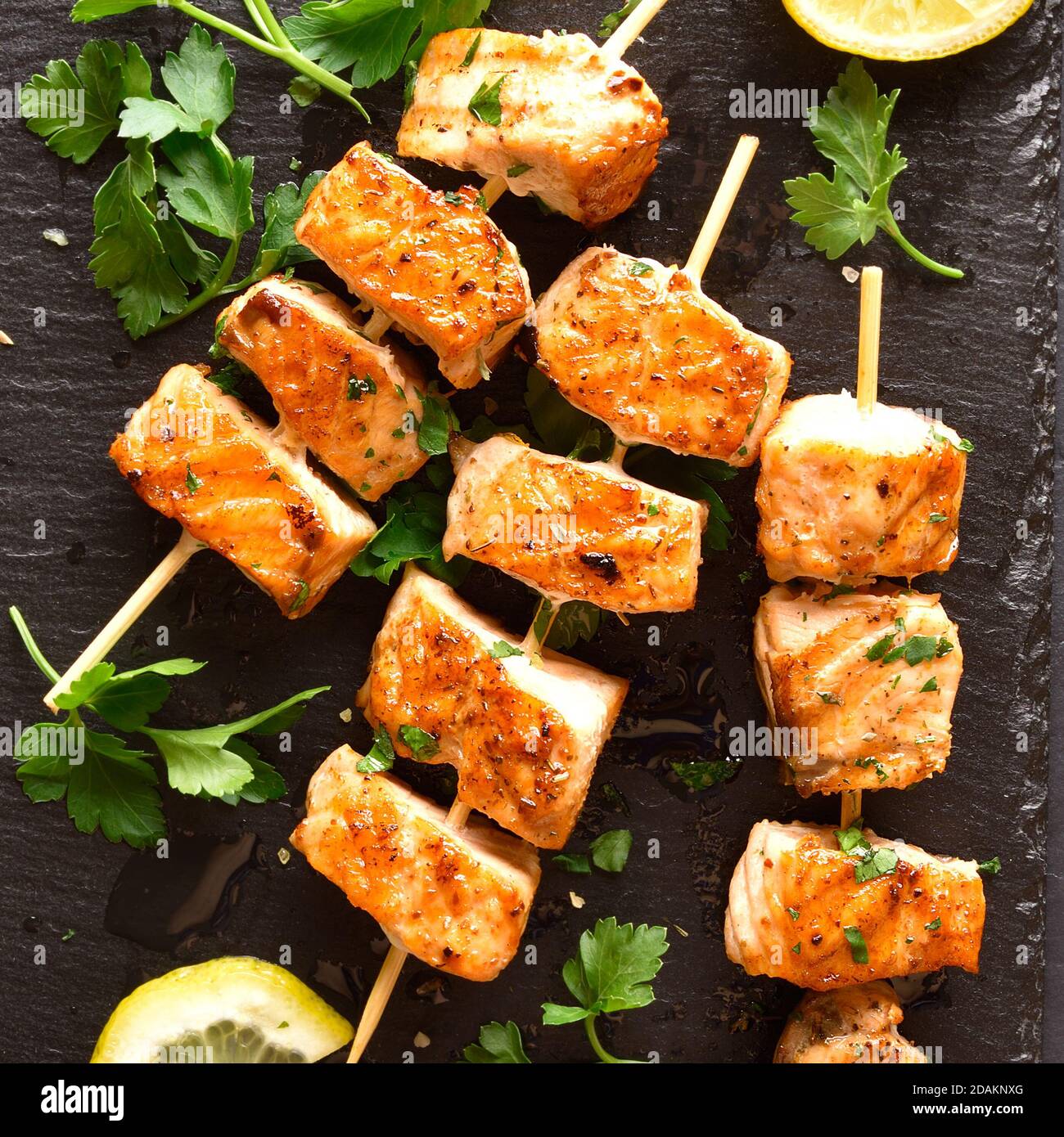 Vista de cerca del kebab de salmón a la parrilla. Brochetas de salmón a la barbacoa sobre pizarra de piedra. Vista superior, disposición plana Foto de stock