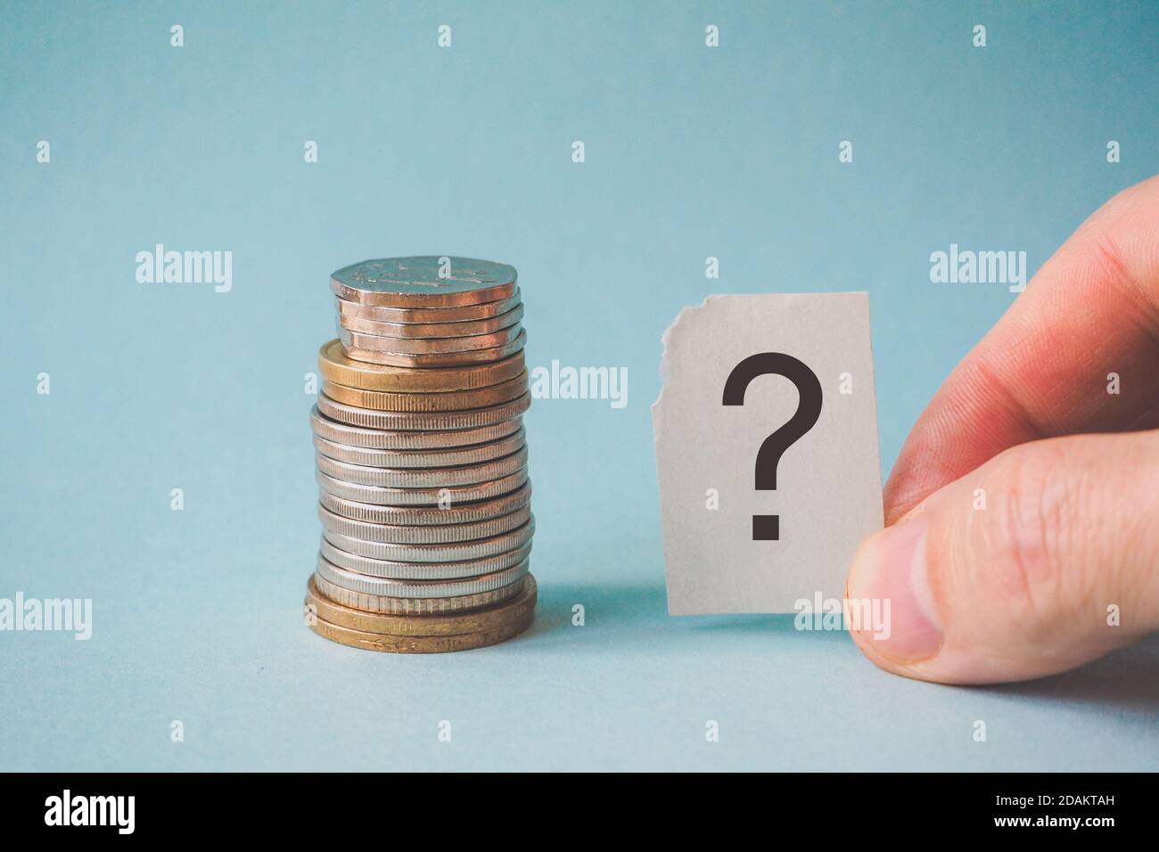 Un signo de interrogación y una pila de monedas Fotografía de stock - Alamy
