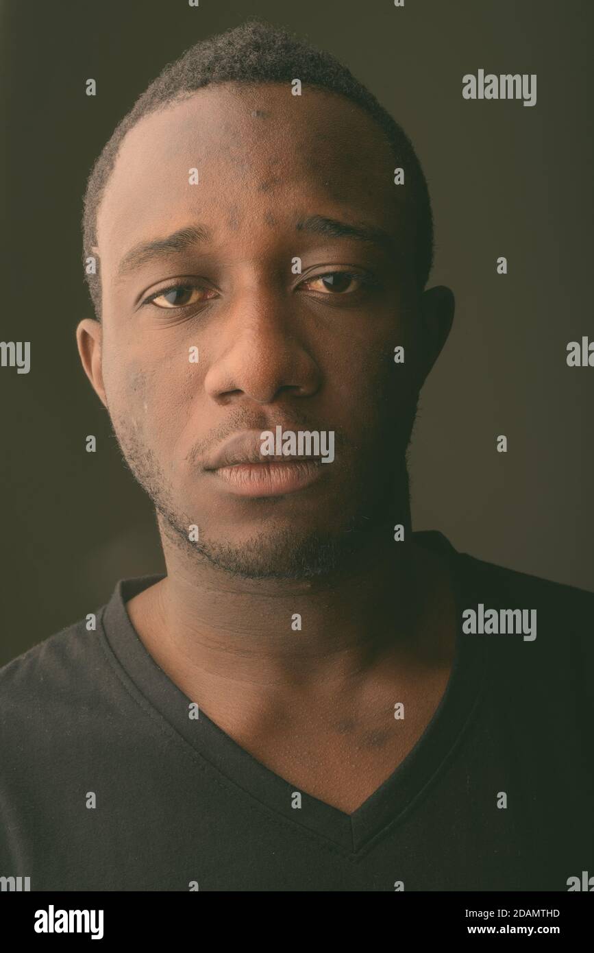 Estudio de un joven africano negro en la habitación oscura Foto de stock