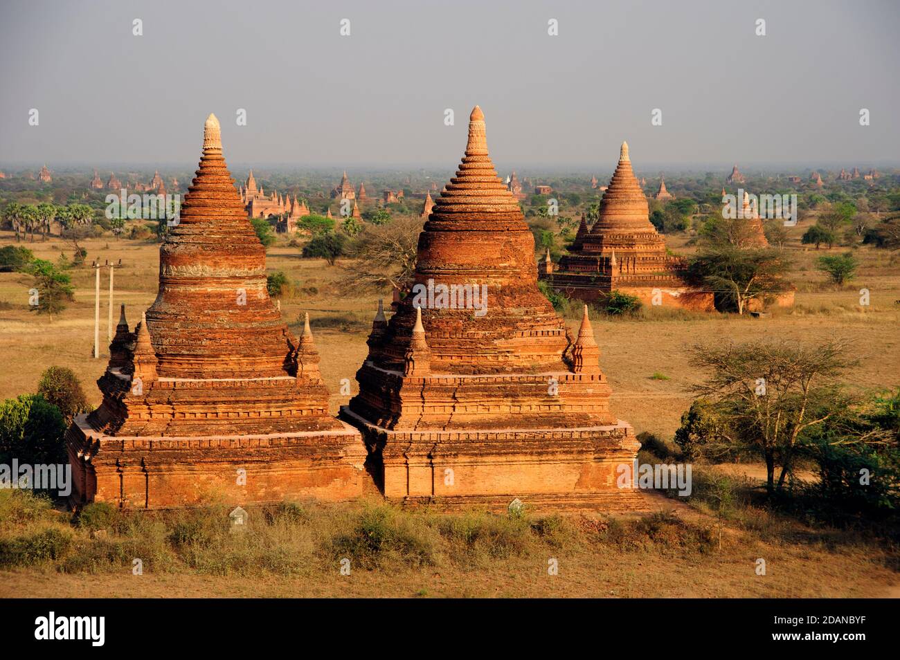 Dos estructuras del templo de ladrillo en el templo salpicado de una llanura polvorienta De la antigua Myanmar Bagan Foto de stock