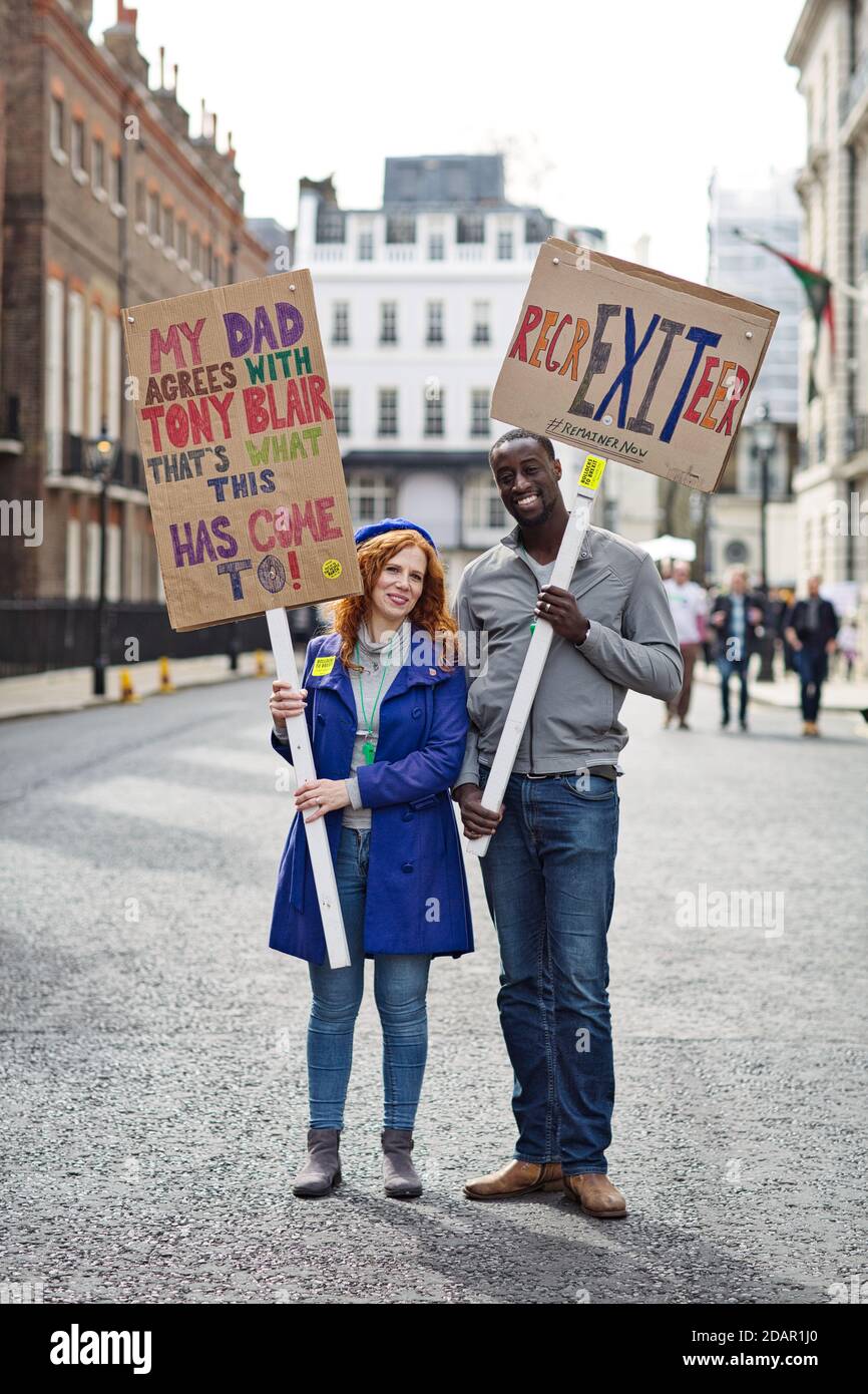 LONDRES, REINO UNIDO - Los manifestantes anti-brexit y la pareja de razas mezcladas que sostenían un cartel durante la protesta anti-Brexit el 23 de marzo de 2019 en Londres. Foto de stock