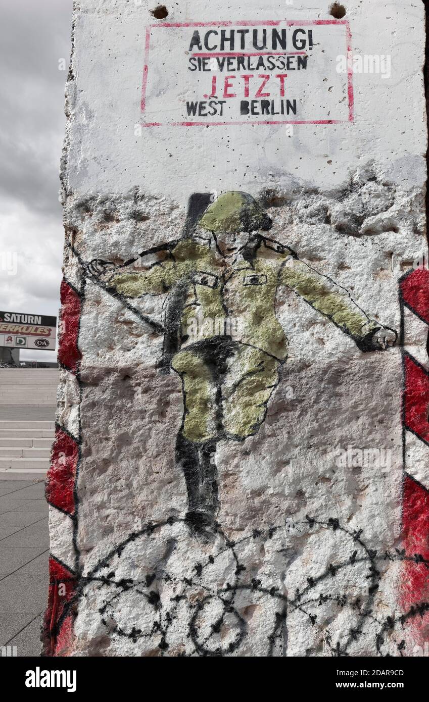 El guardia fronterizo de la RDA salta sobre alambre de púas hacia el oeste, graffito sobre un fragmento del Muro de Berlín, Weimar, Turingia, Alemania Foto de stock