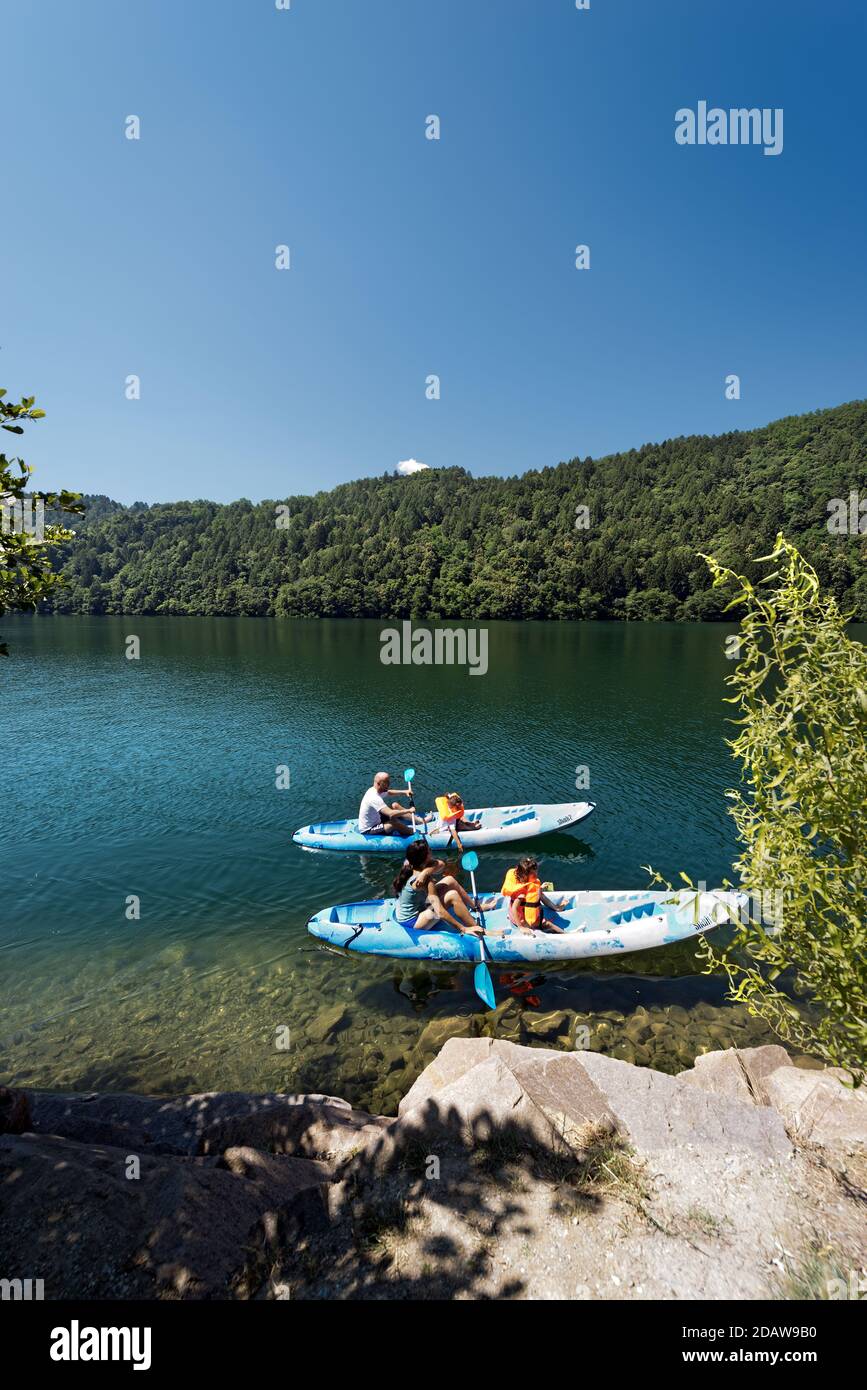 Familia con dos niños en dos kayaks en el hermoso Lago Levico en Valsugana (Valle de Sugana), Trentino Alto Adige, Italia, Europa Foto de stock